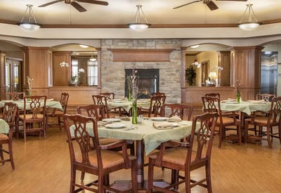 Dining room with tables set for meals and a fireplace