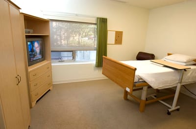 Simple patient room with a bed and TV