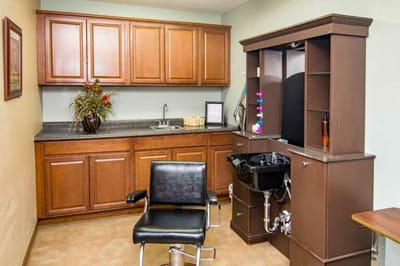 A hair salon area with a styling chair and sink