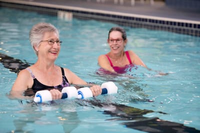Residents exercising in the pool during a water aerobics class