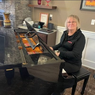 A staff member playing piano in a common area