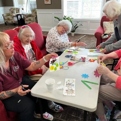 Residents crafting with staff in a cozy activity room
