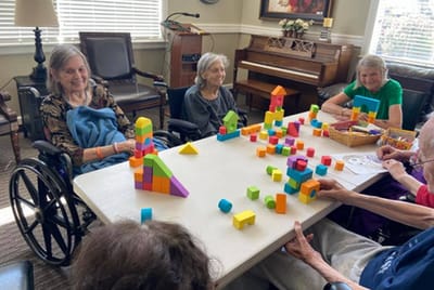 Residents engaging in a creative activity with colorful blocks