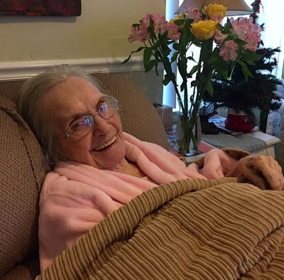 Smiling resident wrapped in a blanket in a cozy room