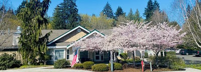 Exterior view of Highland Court Memory Care with cherry blossoms
