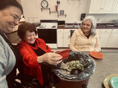 Residents and staff preparing a meal together