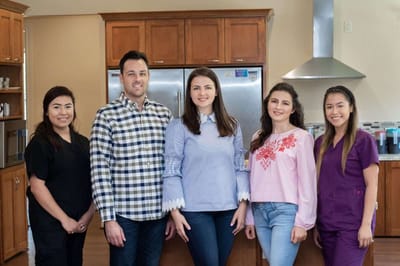 Staff members posing in a bright kitchen area