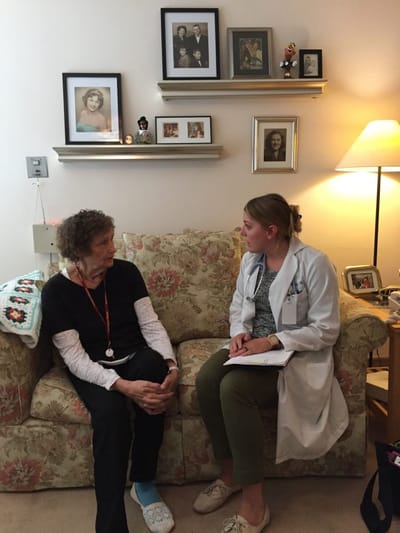 A doctor discussing with a resident in a cozy living room
