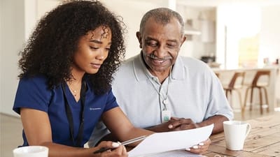 A caregiver assisting a senior resident with paperwork