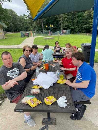 Residents enjoying a meal outdoors at a picnic table