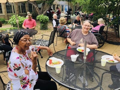 Residents enjoying an outdoor meal at tables