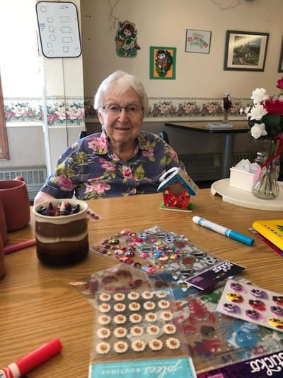 A resident engaging in a crafting activity in a common area
