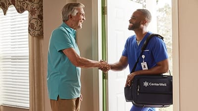 A caregiver greeting a senior at the door