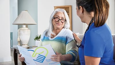 A caregiver talking with a resident in a bright interior