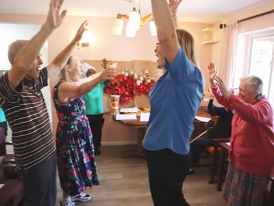 Residents and staff joining in a joyful group activity