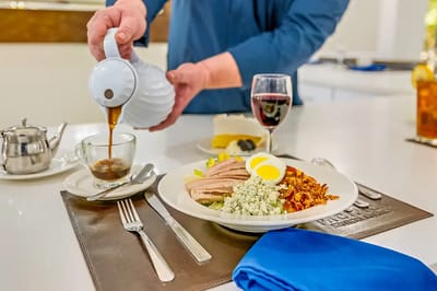 Pouring coffee into a cup with a meal on the table