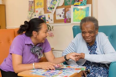 Staff member engaging with a resident during an activity