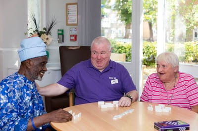 Residents and staff enjoying a game of dominoes