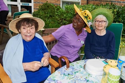 Residents celebrating with staff in a garden setting