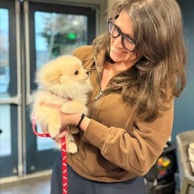 Staff member holding a small puppy indoors