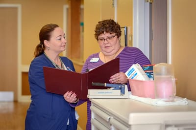 Staff assisting a resident in a hallway