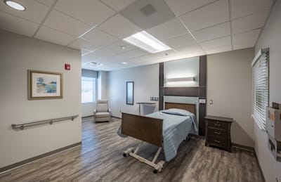 A private resident room with a bed and seating area