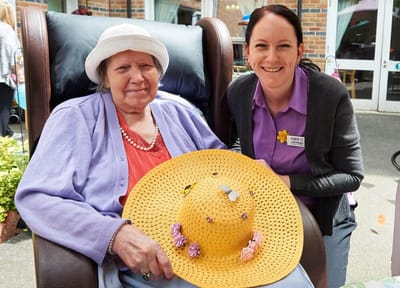 Resident enjoying a sunny day with staff member outside