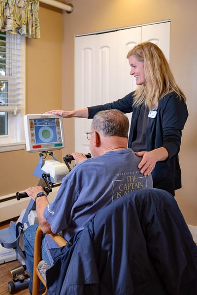 Staff assisting a resident with a therapy machine