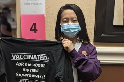 Staff member displaying a vaccination shirt