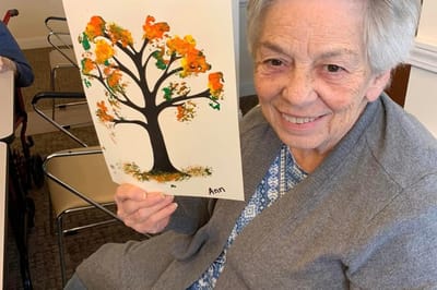 Resident proudly displaying artwork in a common area