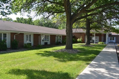 Pathway alongside residential building with trees and lawn