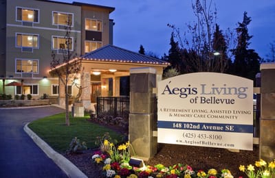 Exterior view of Aegis Living facility entrance at dusk