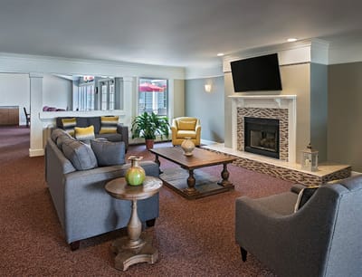 Bright common area with cozy seating and fireplace
