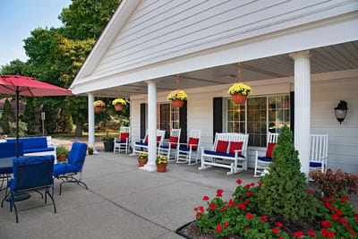 Outdoor seating area with rocking chairs and flowers