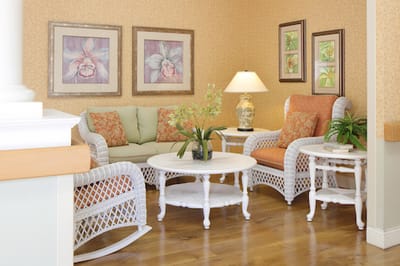 Cozy sitting area with white wicker furniture and decorative paintings