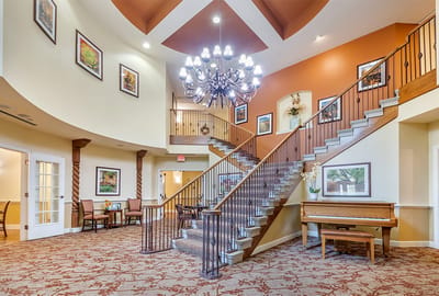 Bright lobby area with a staircase and piano