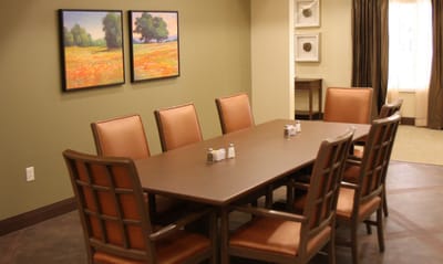 Common area with a dining table and paintings