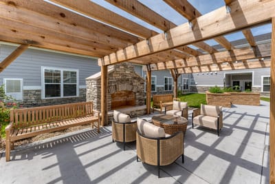 Outdoor seating area with wooden pergola and fireplace