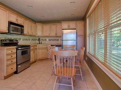 Bright kitchen area with wooden cabinets and dining table
