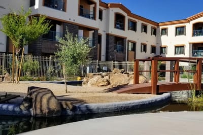 Exterior view of a landscaped courtyard with a bridge