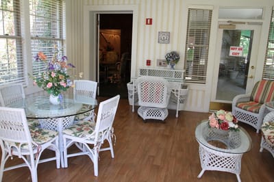 Bright common area with wicker furniture and floral decor