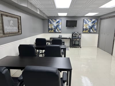 A well-lit activity room with tables and chairs