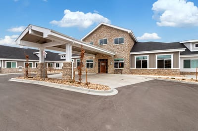 Exterior view of a senior living facility with stone facade
