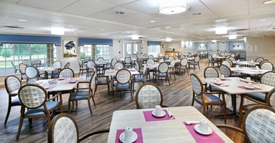 Bright dining room with tables and chairs set for meals