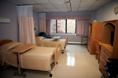 A shared resident room with two beds and a view