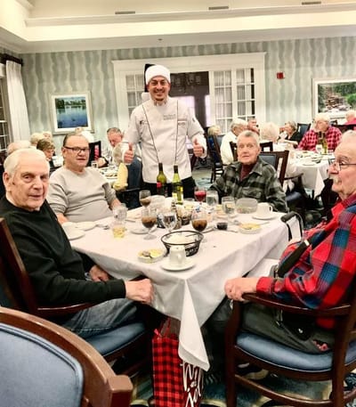 Residents enjoying a meal with the chef in the dining room