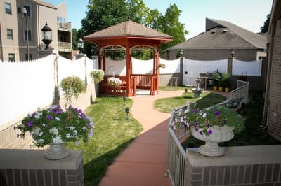 A well-maintained garden with a gazebo surrounded by flowers at Heartwood House.