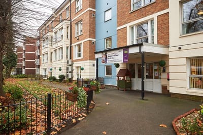 Exterior view of a senior living facility with gardens