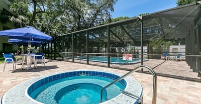 Outdoor pool area with a hot tub and lounge seating