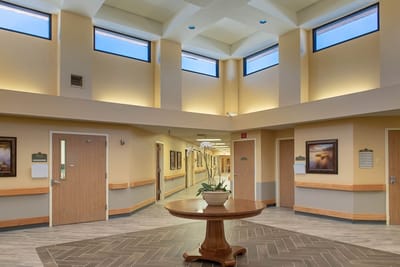 Bright interior hallway with seating area and windows
